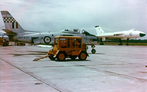 RAAF CAC Sabre of 75 Sqn on standby at Butterworth as an RAF Vulcan B.1 passes by