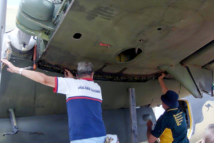 DHC4 Caribou A4-228 volunteers securing main wing attachment bolts
